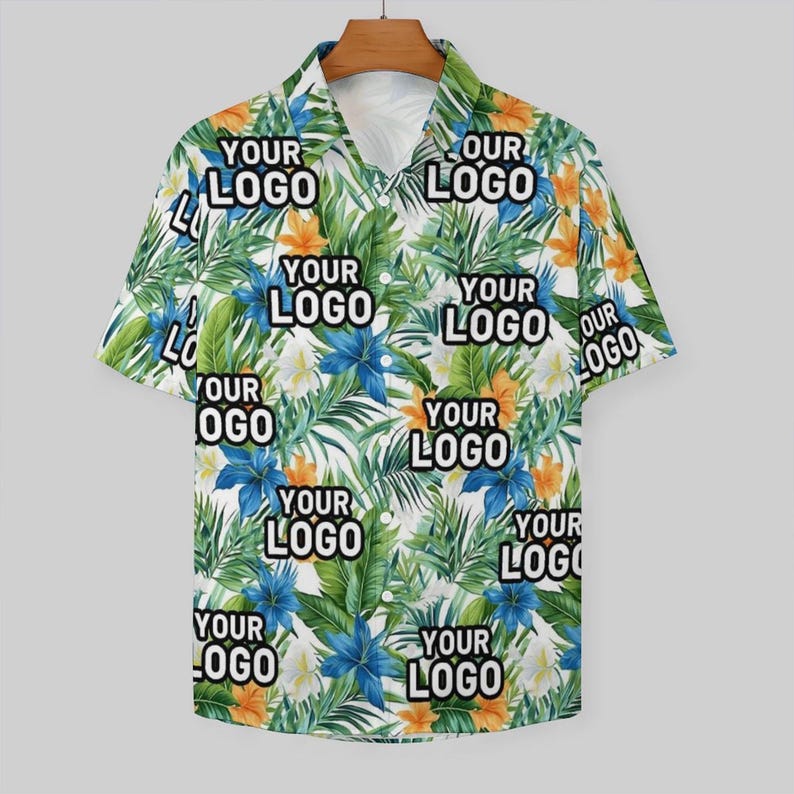 May include: A white short-sleeved button-down shirt with a tropical print. The print features green leaves, blue and orange flowers, and the text "YOUR LOGO" and "OUR LOGO" repeated throughout.