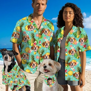 May include: A set of three matching shirts featuring a tropical print with pineapple and dog faces. The shirts are in a light blue color with white accents. The shirts are shown on two adults and a dog.