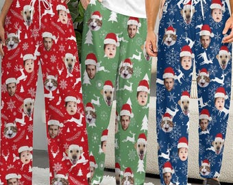 May include: Three pairs of pajama pants in red, green, and blue, each featuring a repeating pattern of white snowflakes, reindeer, Christmas trees, and personalized faces of people, cats, and dogs wearing small red Santa hats with white trim.