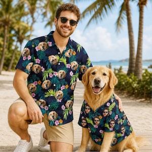 Peut inclure: Une chemise à manches courtes boutonnée avec un motif tropical bleu foncé, des feuilles de palmier vertes, des fleurs d'hibiscus roses et jaunes, et une impression répétée du visage d'un golden retriever. Col et boutons blancs.
