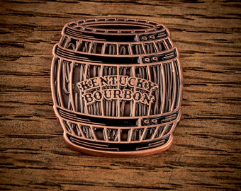 May include: A copper-colored metal pin shaped like a barrel with the words "Kentucky Bourbon" on the front.