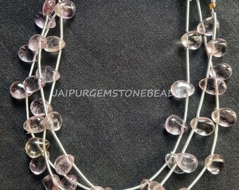 May include: A strand of pale pink gemstone beads, strung on silver wire. The beads are oval shaped and have a translucent appearance.