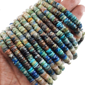 May include: A strand of turquoise gemstone beads, featuring a mix of blue, green, brown, and white colors. The beads are round and have a smooth, polished finish.