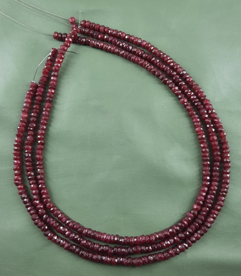 Puede incluir: Tres hebras de cuentas facetadas de color rojo rub&iacute; enhebradas en alambre plateado.