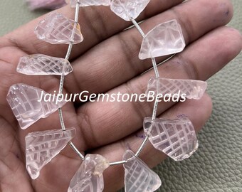 May include: Strand of light pink, faceted gemstone beads. The beads are strung on a silver wire and have a textured, geometric pattern. The text "JaipurGemstoneBeads" is visible.