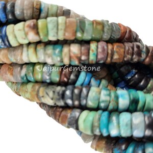May include: A strand of multi-colored gemstone beads. The beads are small and round, and they are arranged in a random pattern. The colors of the beads include blue, green, brown, and white.