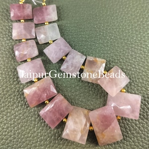May include: A strand of pink and white gemstone beads with gold spacers. The beads are rectangular and faceted. The text "Jaipur Gemstone Beads" is visible in the image.