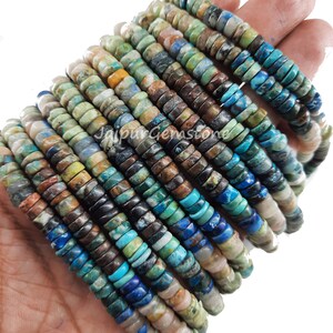 May include: A strand of turquoise gemstone beads, featuring a mix of blue, green, brown, and white colors. The beads are round and have a smooth, polished finish.