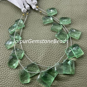 May include: Strands of faceted, light green gemstone beads. The beads are strung on a silver chain and are rectangular and square-shaped. The text "JaipurGemstoneBeads" is visible on the image.