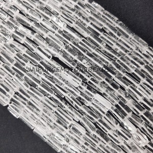 Può includere: Una collana di perle di cristallo di quarzo trasparente, ogni perla è un prisma rettangolare con una superficie liscia e lucida. Le perle sono disposte a spina di pesce, creando una texture visivamente accattivante. Le perle misurano circa 10 mm di lunghezza e 5 mm di larghezza.