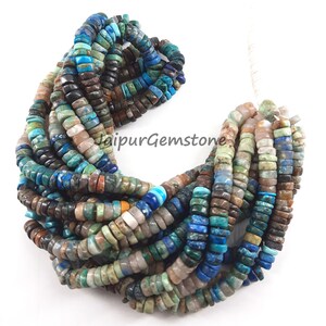 May include: A strand of mixed gemstone beads in shades of blue, green, brown, and white. The beads are small and round, and they are strung together on a clear thread. The beads are arranged in a loose, flowing pattern.