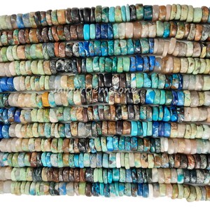 May include: A strand of mixed gemstone beads, featuring a variety of colors and patterns. The beads are small and round, with a mix of turquoise, blue, brown, and green hues. The beads are strung on a clear thread and are ready to be used for jewelry making.