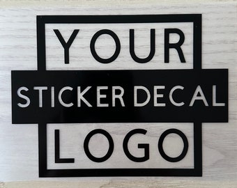 May include: Black and white sticker decal with the text "YOUR STICKER DECAL LOGO" in a square frame.