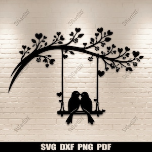 May include: Black metal wall art featuring a tree branch with heart-shaped leaves and flowers. Two birds are perched on a swing, kissing. The art is mounted on a white brick wall. The bottom of the image has the text "SVG DXF PNG PDF".