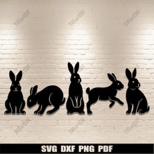 Può includere: Cinque sagome nere di conigli in varie pose sono mostrate contro un muro di mattoni bianchi. I conigli sono tagliati da un materiale solido, creando un'estetica minimalista. Il testo "SVG DXF PNG PDF" è visualizzato nella parte inferiore dell'immagine.