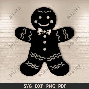 May include: Black gingerbread man silhouette with white accents, including a bow tie, buttons, and wavy lines. The image includes the text "SVG DXF PNG PDF".