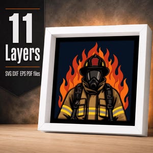 Puede incluir: Una obra de arte en papel multicapa enmarcada que representa a un bombero con uniforme color canela, franjas reflectantes amarillas, casco negro y máscara de gas, sobre un fondo de llamas naranjas y rojas. El texto dice 11 Layers SVG DXF EPS PDF files.