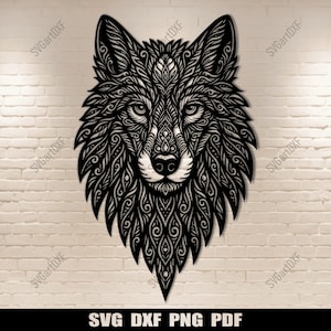 May include: Black laser-cut wolf head wall art. The wolf's face is intricately detailed with swirling patterns. The artwork is mounted on a white brick wall. The bottom of the image displays the text: SVG DXF PNG PDF.
