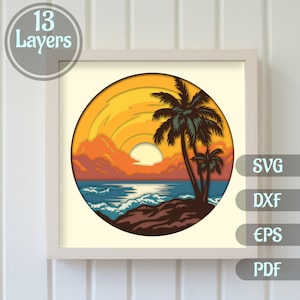 May include: A 13-layer papercraft design of a sunset over a beach with palm trees. The design is in a circle and has a yellow, orange, and red sunset with a blue ocean and brown sand.