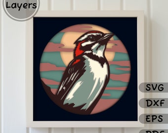 May include: A layered papercraft design of a bird with red, white, and black markings, perched on a branch in front of a full moon with a blue and pink sky.