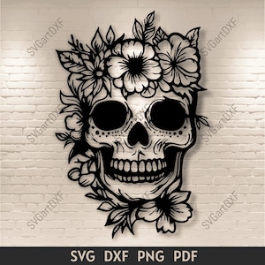 Può includere: Illustrazione in bianco e nero di un teschio di zucchero con fiori intorno alla testa. Il teschio è dettagliato con disegni intricati e i fiori sono stilizzati.