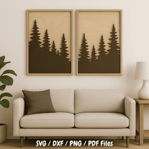 May include: Two framed wall art pieces featuring a forest silhouette design. The artwork has a dark brown forest cut-out against a light brown background, set within a light brown wooden frame. The bottom of the image has the text "SVG / DXF / PNG / PDF Files".