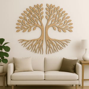 Puede incluir: Una gran obra de arte mural de madera del árbol de la vida, con un diseño simétrico de hojas y raíces. La obra de arte es de color marrón claro y está montada en una pared blanca sobre un sofá color crema.