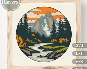 Puede incluir: Un diseño de papelcraft de 15 capas que representa una escena de montaña con un río que fluye a través de un bosque. La escena se desarrolla en un cielo de puesta de sol con nubes. El diseño está en un marco circular.