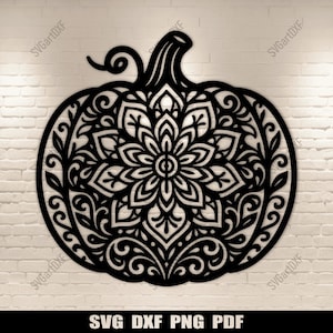 Op de afbeelding: Zwarte pompoenvormige wandkunst met een ingewikkeld mandala-ontwerp. De pompoen heeft een steel en een gedetailleerd bloemmotief in de omtrek. De tekst "SVG DXF PNG PDF" staat onderaan.
