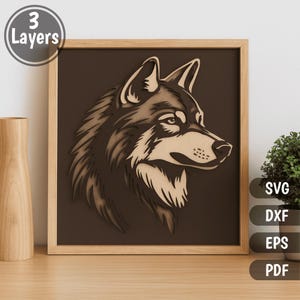 May include: A framed, three-layer wooden artwork depicting a wolf's head in profile. The piece is predominantly brown and tan, with the text "3 Layers" in a circle in the upper left. The frame is light brown. The image also includes SVG, DXF, EPS, and PDF file options.