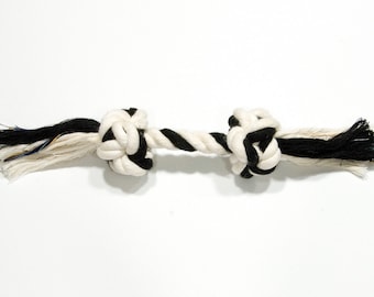 May include: A white and black rope dog toy with two knots at each end. The rope is thick and durable, making it a great choice for dogs who love to chew.