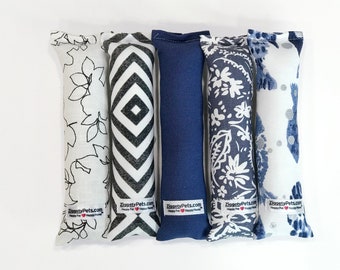 May include: Five catnip toys in different patterns. The toys are made of fabric and have a rectangular shape. The patterns include floral, geometric, and solid blue. Each toy has a label that says "ZiggetyPets.com Happy Pet, Happy Home".