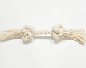 May include: A white cotton rope dog toy with two knotted ends.