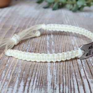 Puede incluir: Una pulsera trenzada blanca con un dije plateado que dice "what I've been through makes me stronger".