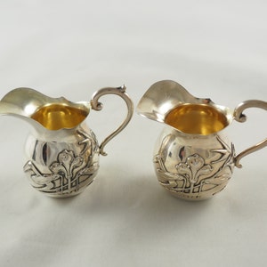 Un paio di brocche di crema d&#39;argento massiccio art nouveau antico, in argento standard 800, con un giglio stilizzato, Maker Kuhn Brothers, Geramany 1900