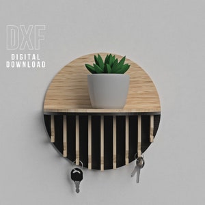 Puede incluir: Estantería de pared redonda de dos tonos, con parte superior de madera clara e inferior de listones negros. Una maceta blanca con una planta verde está en la estantería. Dos llaves cuelgan de la parte inferior. Texto "DXF DIGITAL DOWNLOAD".