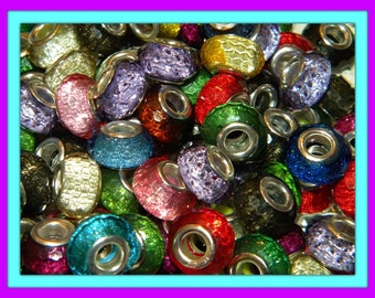Könnte beinhalten: Eine Ansammlung von runden, fassförmigen Perlen mit einer texturierten, glitzernden Oberfläche in verschiedenen Farben wie Rot, Blau, Grün, Lila, Gold und Schwarz. Jede Perle hat einen zentralen Kern aus silberfarbenem Metall.