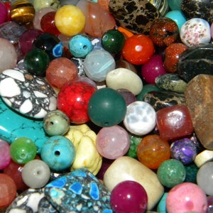 May include: A large assortment of colorful gemstone beads in various shapes and sizes. The beads are made of turquoise, agate, jasper, and other natural stones.