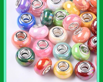 May include: A collection of colorful, iridescent glass beads with silver-toned metal cores. The beads are in various shades of pink, green, blue, yellow, and purple. These beads are suitable for jewelry making and other craft projects.