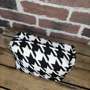 May include: Black and white houndstooth patterned zippered pouch or cosmetic bag.