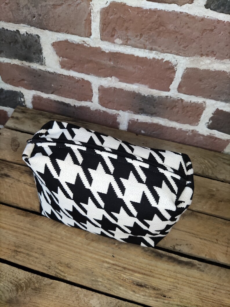 May include: Black and white houndstooth patterned zippered pouch or cosmetic bag.
