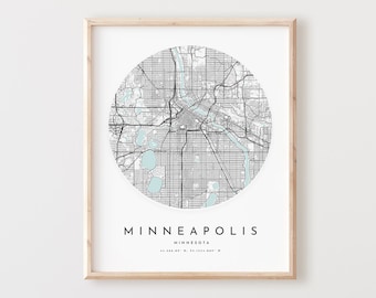 May include: A black and white map of Minneapolis, Minnesota, in a circle with a light blue background. The map is framed in a light wood frame.