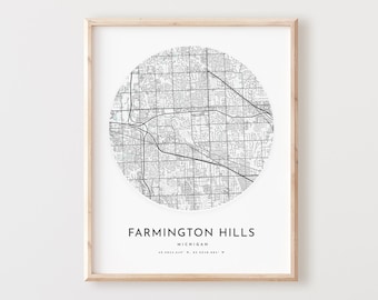 May include: A black and white map of Farmington Hills, Michigan, in a circular frame. The map is printed on white paper and framed in a light wood frame.