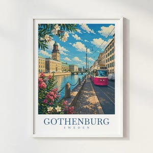 Op de afbeelding: Een ingelijste kunstdruk van het stadsgezicht van Göteborg, Zweden, met een felroze tram op rails, een kanaal, historische gebouwen met een hoge toren en bloeiende roze bloemen op de voorgrond onder een blauwe lucht met witte wolken.