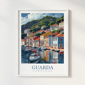 May include: A framed art print of Guarda, Portugal, showing a vibrant waterfront. The image features buildings in blue, yellow, and red, with boats on the water. The text "GUARDA PORTUGAL" is printed at the bottom of the artwork.