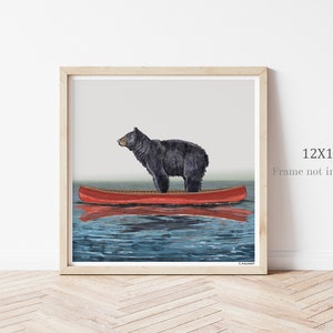 May include: A black bear standing in a red canoe on a blue lake. The image is a 12x12 inch print, frame not included.