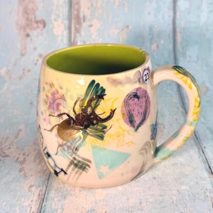 Tazza in ceramica gialla con collage patchwork, realizzata a mano.