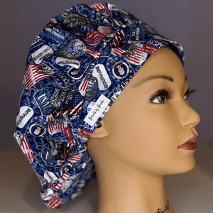 Puede incluir: Un gorro de quirófano azul y rojo con estampado de varios parches y textos de temática militar, entre ellos "USAF", "Valor", "Respeto" e "Integridad".
