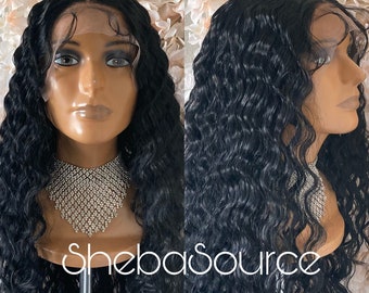 May include: A black human hair wig with loose, wavy curls. The wig is on a mannequin head and has a lace front.