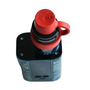 May include: A black and blue electronic cigarette with a red silicone cap that says "ATIKAP" on it.